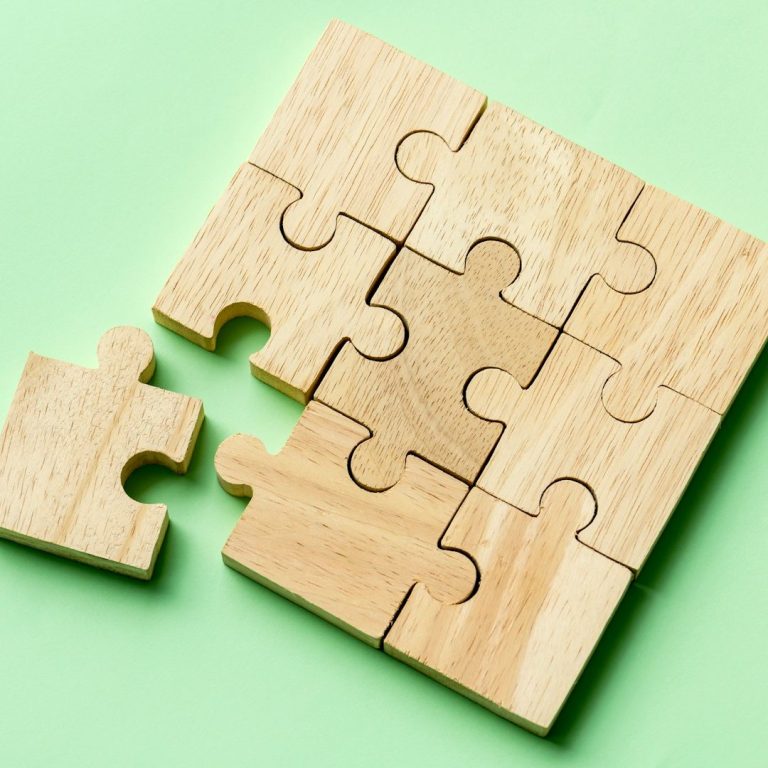 Holzpuzzle mit einem fehlenden Teil auf grünem Hintergrund, Klarheit, Karriere